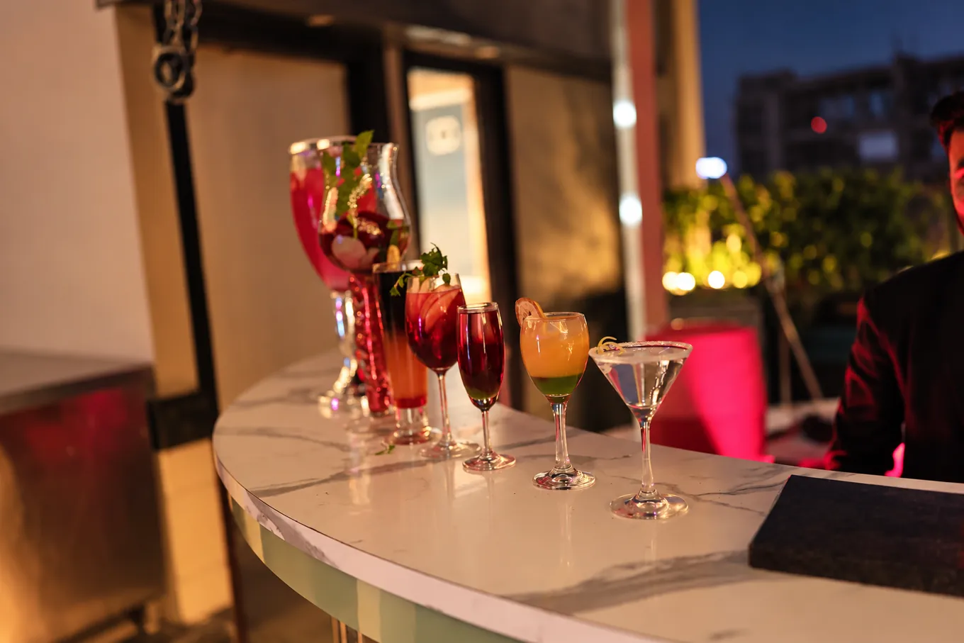 Assorted drinks in stemmed glasses on a curved marble counter