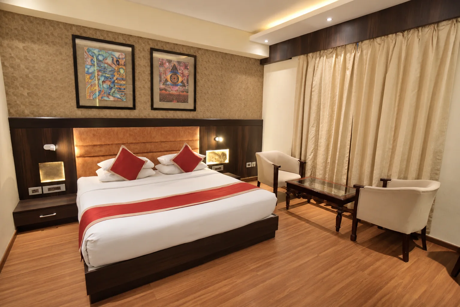 Guest room with upholstered headboard and seating at Hotel Ranbirs
